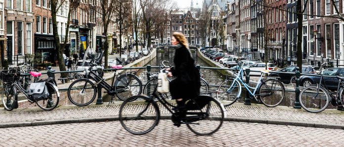 Amsterdam,Cyclist,Traveling,Over,A,Bridge.